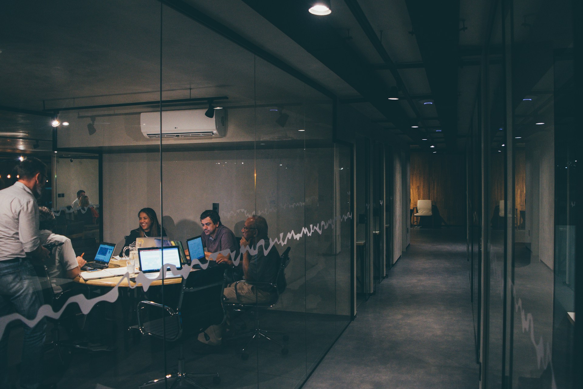 A team coordinating work in a glass meeting room